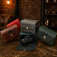 Multiple leather camera bags with monogram initials on textured surface