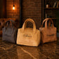 Three leather handbags with names engraved on them, placed on a marble surface.
