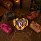 Collection of leather bags on a textured surface with a warm ambiance.