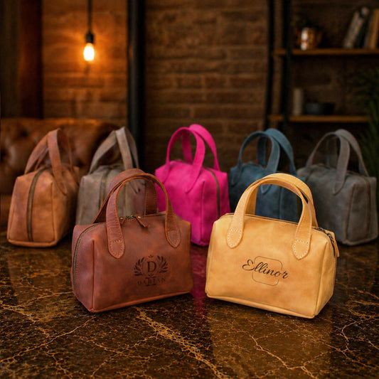 Collection of handbags in various colors on a textured surface with a warm light in the background.