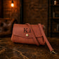 Brown leather handbag with initials on a dark surface