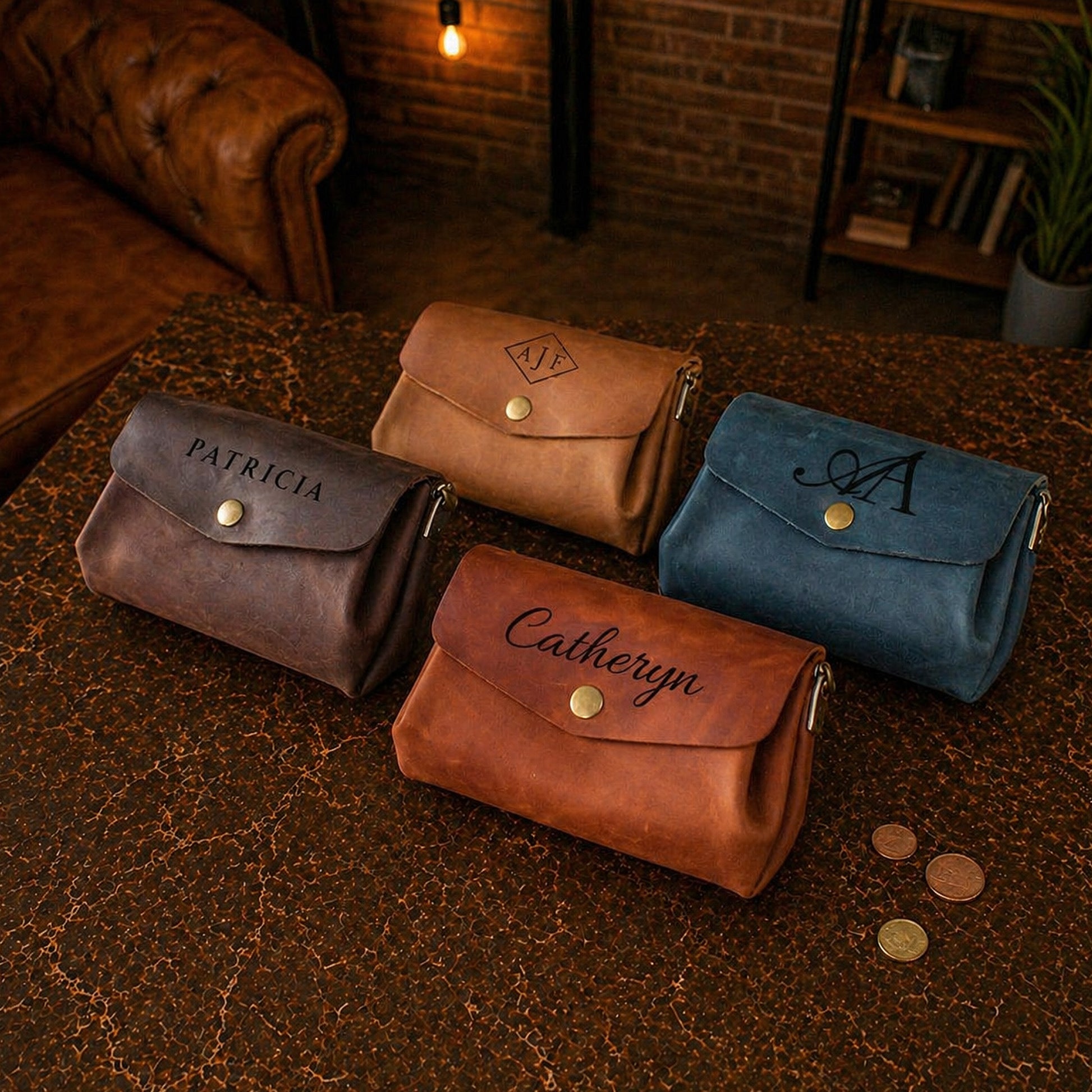Four leather bags with personalized names on a textured surface.